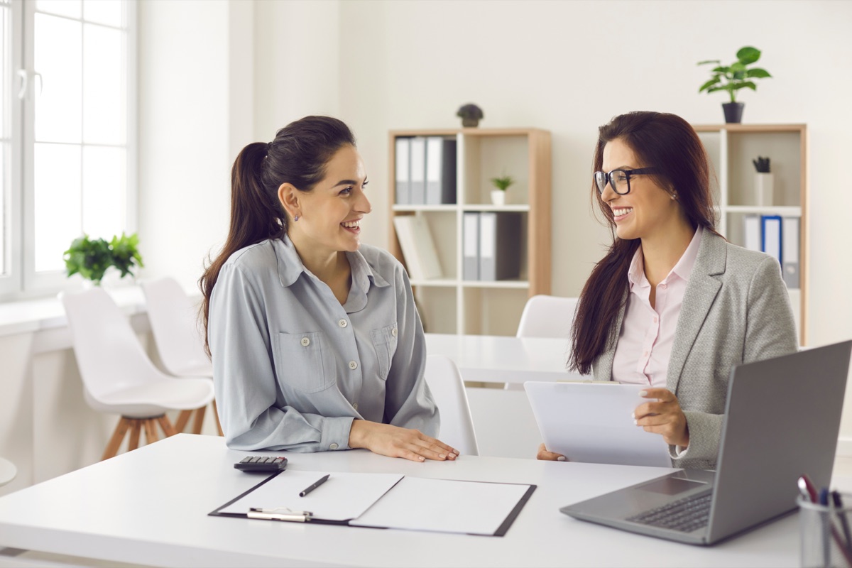 A credit manager and a business customer reviewing a commercial credit application together at an office desk